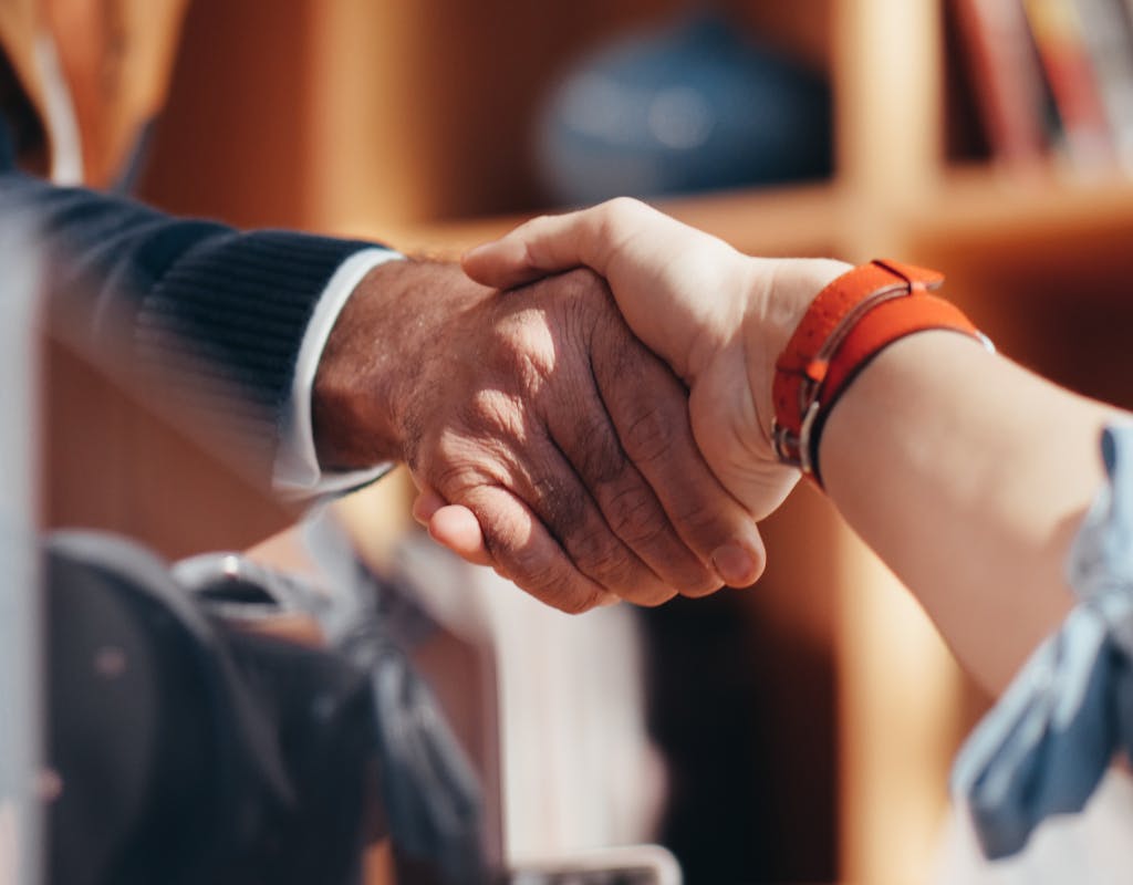 A close-up image of two people shaking hands, symbolizing a business agreement.